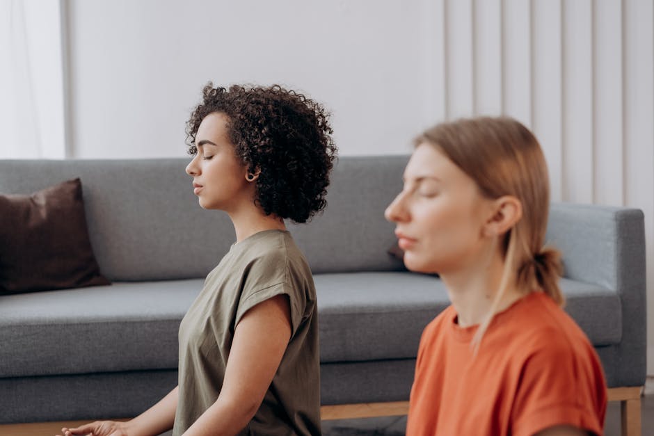Woman practicing a gentle yoga pose with eyes closed, looking serene in a bright room